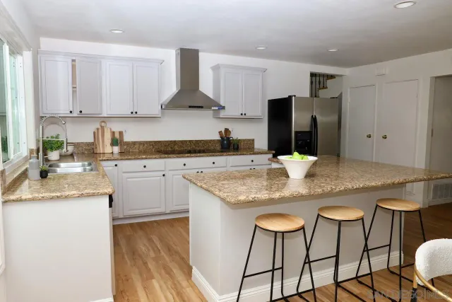 a kitchen with stainless steel appliances granite countertop a sink and a refrigerator