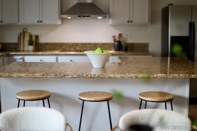 a kitchen with stainless steel appliances granite countertop a table chairs stove and cabinets