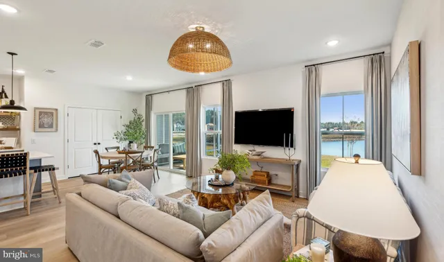a living room with furniture a flat screen tv and a large window