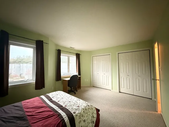 a bedroom with a bed next to a window