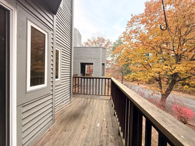 a balcony with wooden floor and fence