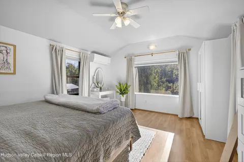 a bedroom with a bed and a large window with outer view