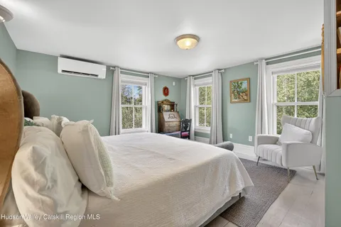 a bedroom with a bed and a large window