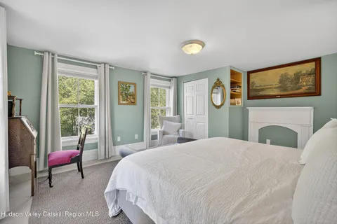 a spacious bedroom with a bed and glass windows