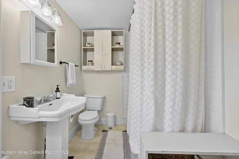 a bathroom with a sink toilet and mirror