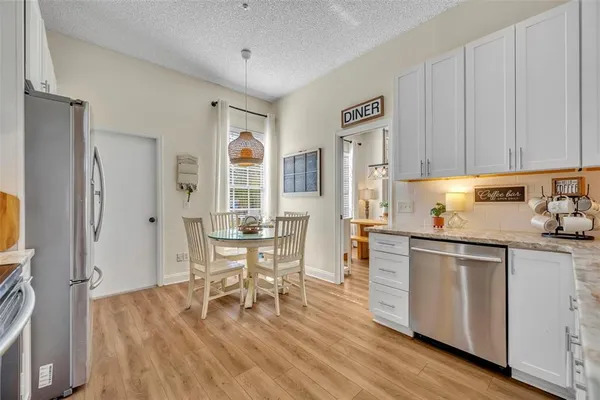 a kitchen with granite countertop wooden floor stainless steel appliances and dining table