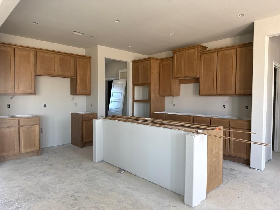 137 Moss Gln Lane Rhome, TX 76078 - Photo 5 of 12 a kitchen with stainless steel appliances granite countertop a stove a sink and a refrigerator