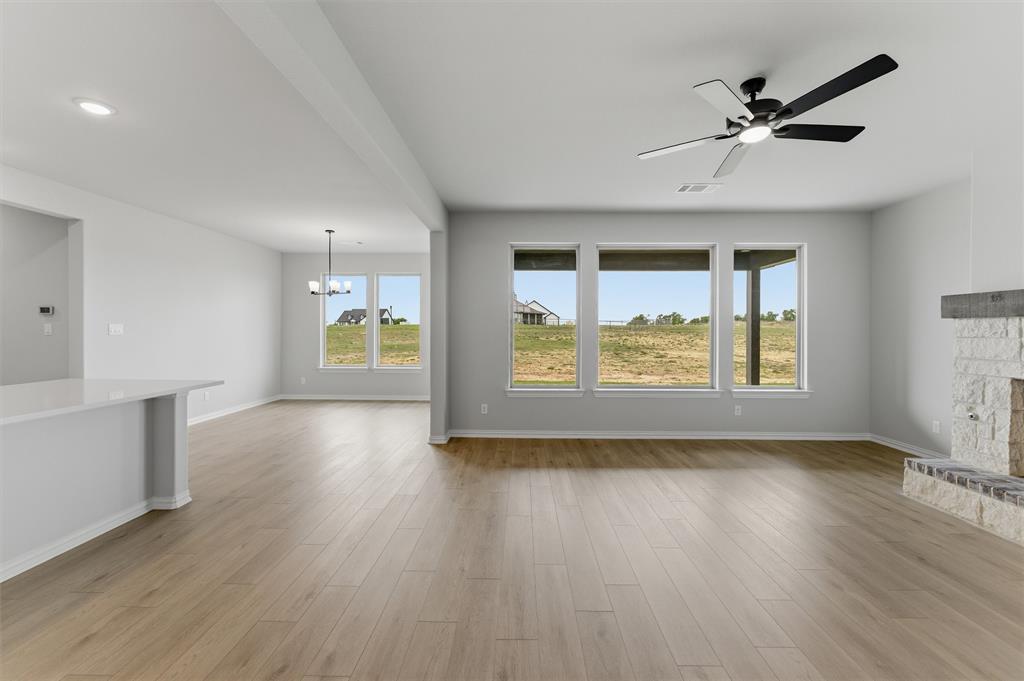 137 Moss Gln Lane Rhome, TX 76078 - Photo 7 of 25 a view of an empty room with a window and wooden floor