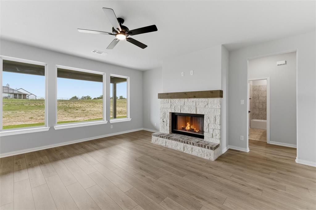 137 Moss Gln Lane Rhome, TX 76078 - Photo 8 of 25 a living room with a fireplace with wooden floor