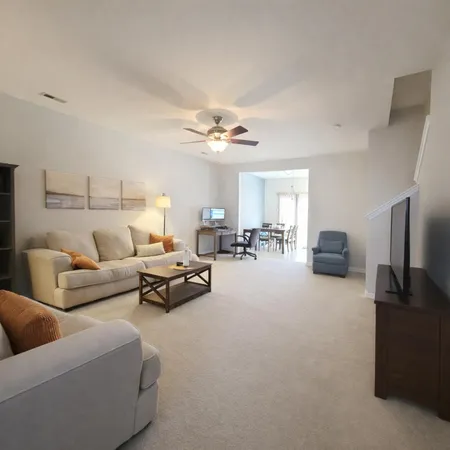 a living room with furniture and a chandelier
