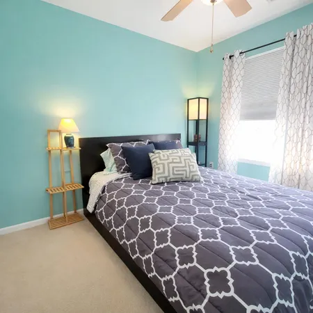 a bedroom with a large bed and a lamp