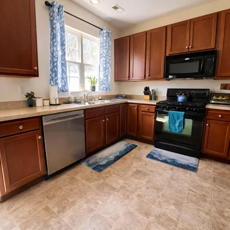 a kitchen with stainless steel appliances granite countertop a stove sink and cabinets