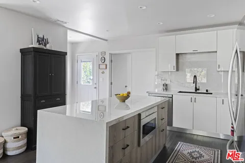 a kitchen with a sink and wooden floor
