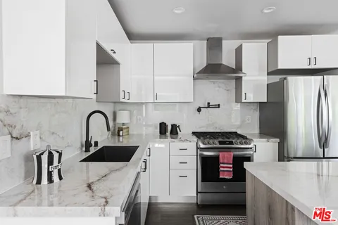 a kitchen with stainless steel appliances granite countertop a sink stove and refrigerator