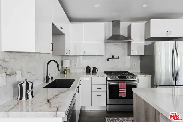 a kitchen with stainless steel appliances granite countertop a sink stove and refrigerator