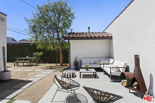 a living room with furniture a flat screen tv and a large tree