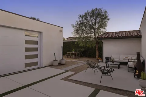 a patio with glass top table and chairs