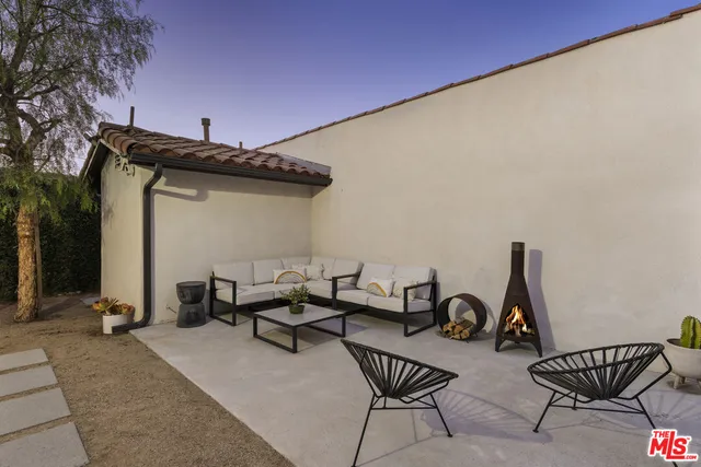 a view of a patio with chairs and potted plants