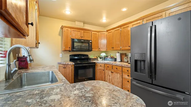 a kitchen with stainless steel appliances granite countertop a refrigerator a stove top oven a sink and dishwasher