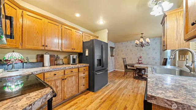 a kitchen with granite countertop a stove refrigerator and cabinets