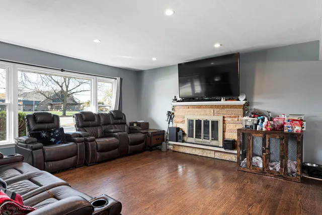 a living room with furniture a flat screen tv and a floor to ceiling window