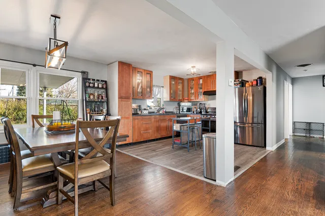 a view of a dining room with furniture a kitchen and chandelier