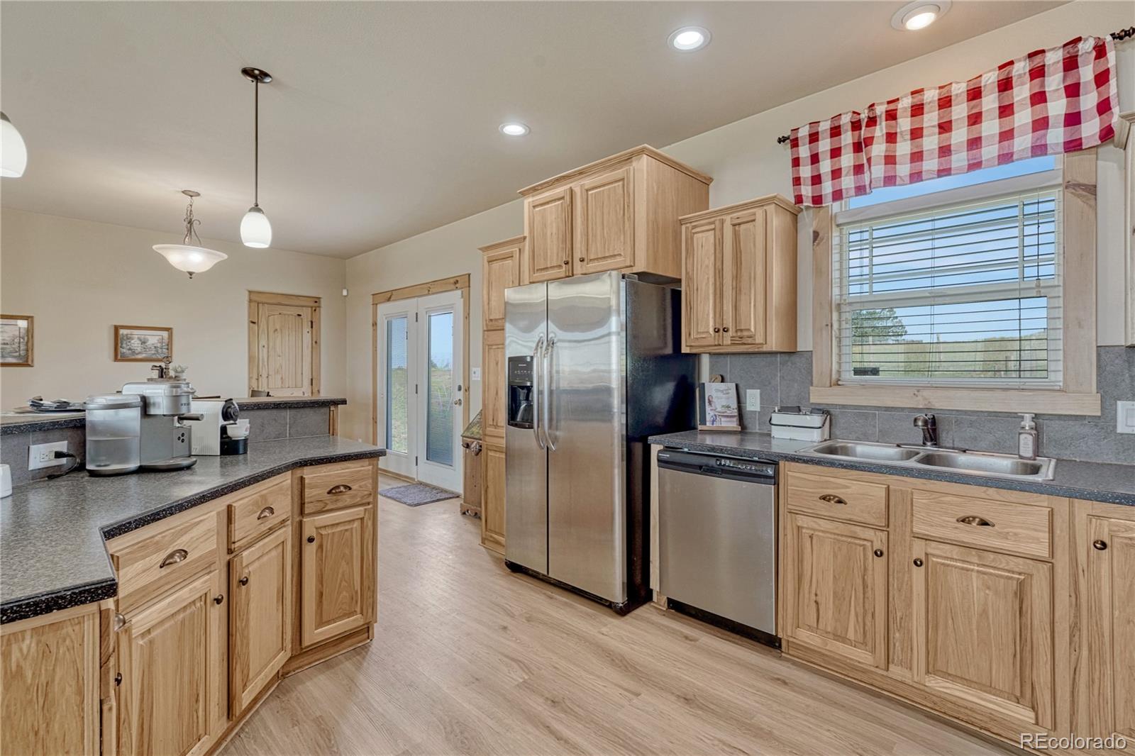 17355 Wagon Train Loop Peyton, CO 80831 - Photo 11 of 48 a kitchen with stainless steel appliances granite countertop a sink a stove and refrigerator