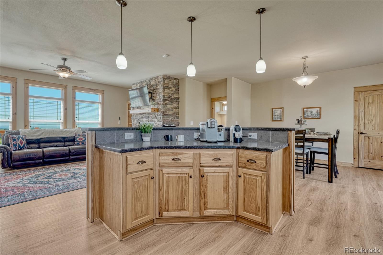 17355 Wagon Train Loop Peyton, CO 80831 - Photo 12 of 48 a large kitchen with lots of counter space a sink appliances and living room view