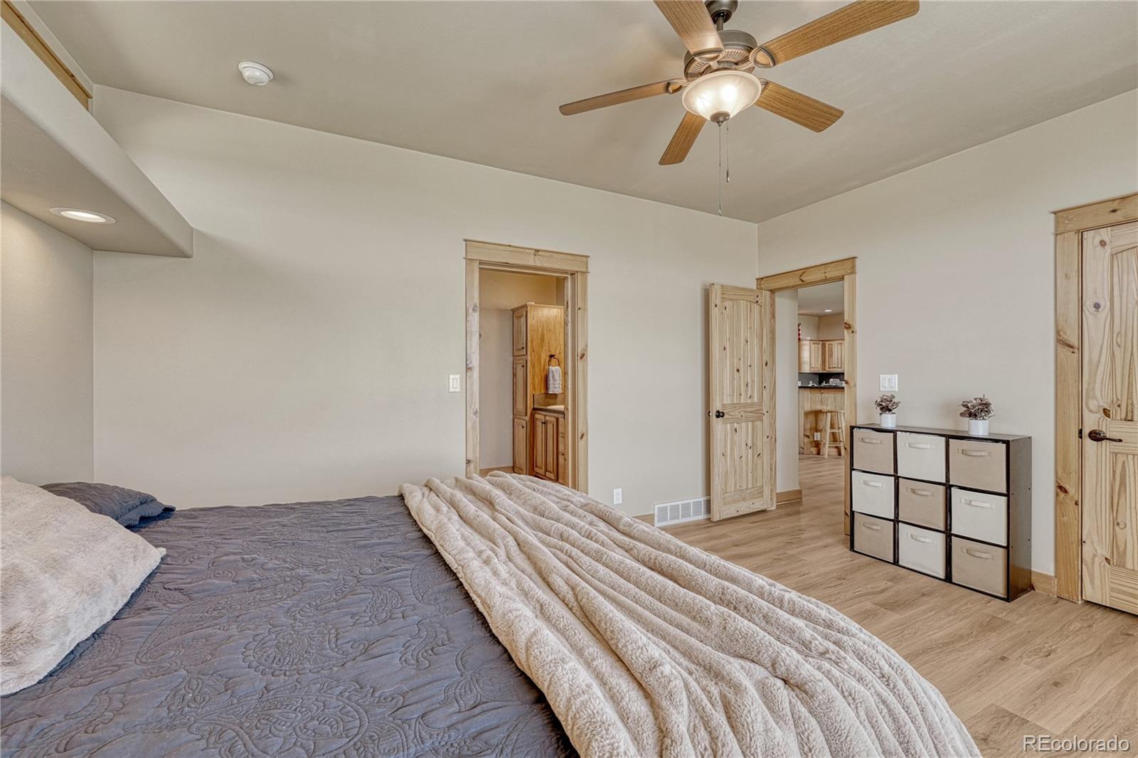 17355 Wagon Train Loop Peyton, CO 80831 - Photo 18 of 48 a bedroom with a bed and a chandelier