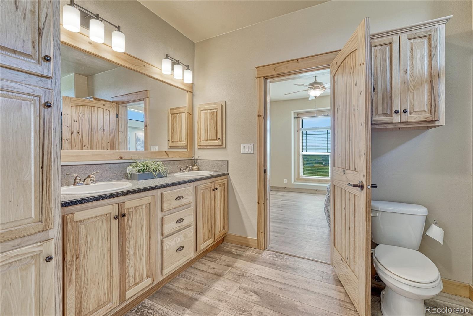 17355 Wagon Train Loop Peyton, CO 80831 - Photo 20 of 48 a spacious bathroom with a granite countertop sink toilet and mirror