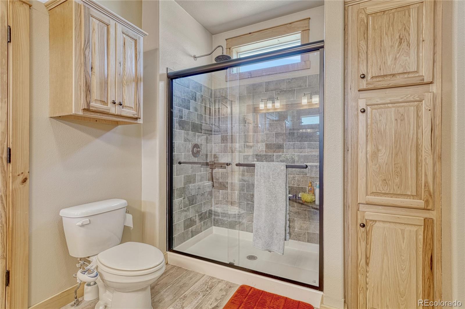 17355 Wagon Train Loop Peyton, CO 80831 - Photo 21 of 48 a bathroom with a glass shower door