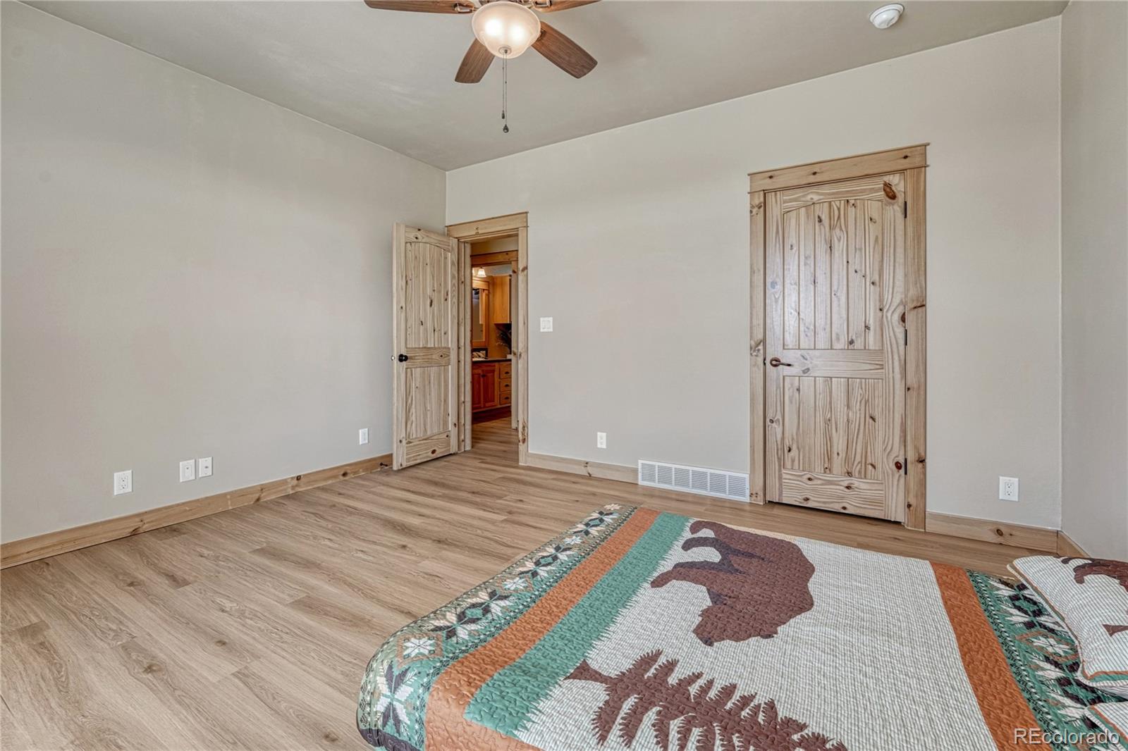 17355 Wagon Train Loop Peyton, CO 80831 - Photo 25 of 48 a bedroom with a bed and a chandelier