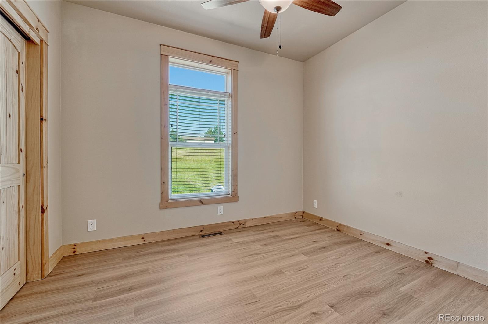 17355 Wagon Train Loop Peyton, CO 80831 - Photo 27 of 48 an empty room with wooden floor and windows