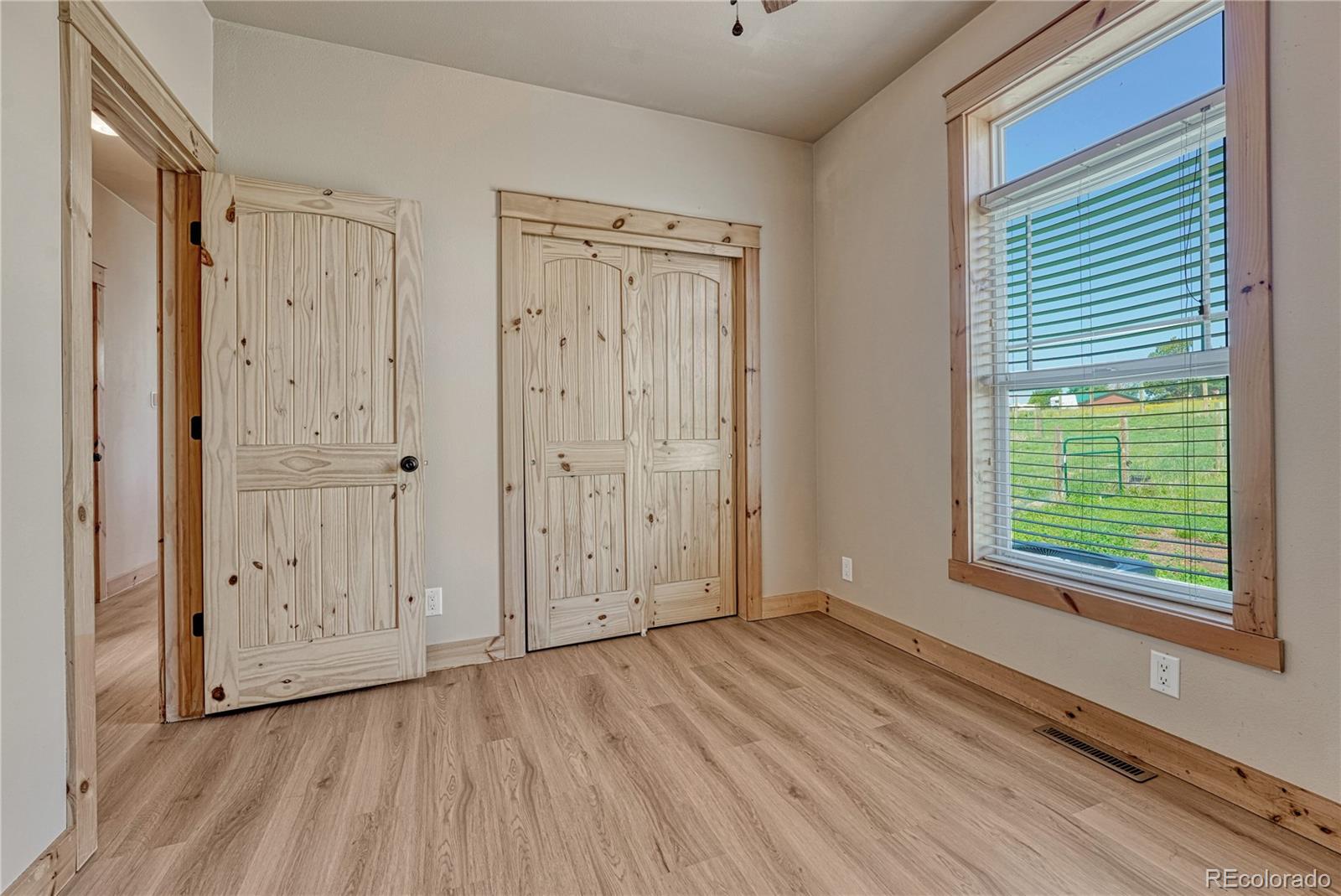 17355 Wagon Train Loop Peyton, CO 80831 - Photo 28 of 48 a view of an empty room with wooden floor and a window