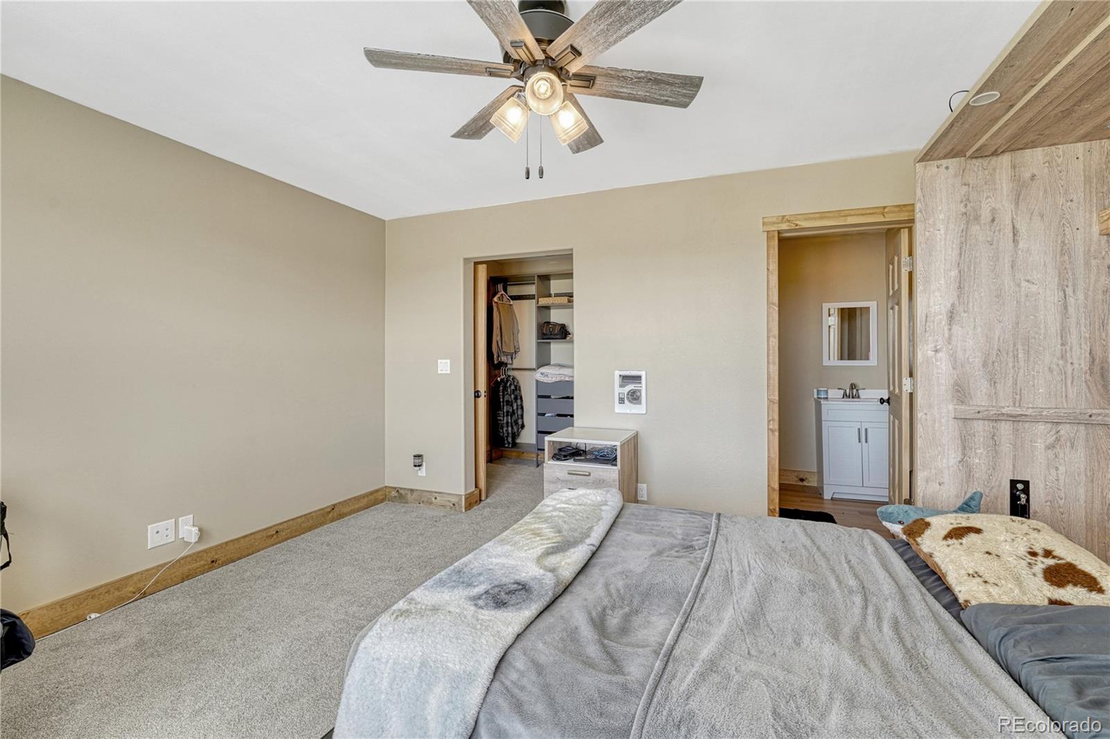 17355 Wagon Train Loop Peyton, CO 80831 - Photo 34 of 48 a bedroom with a bed and a chandelier