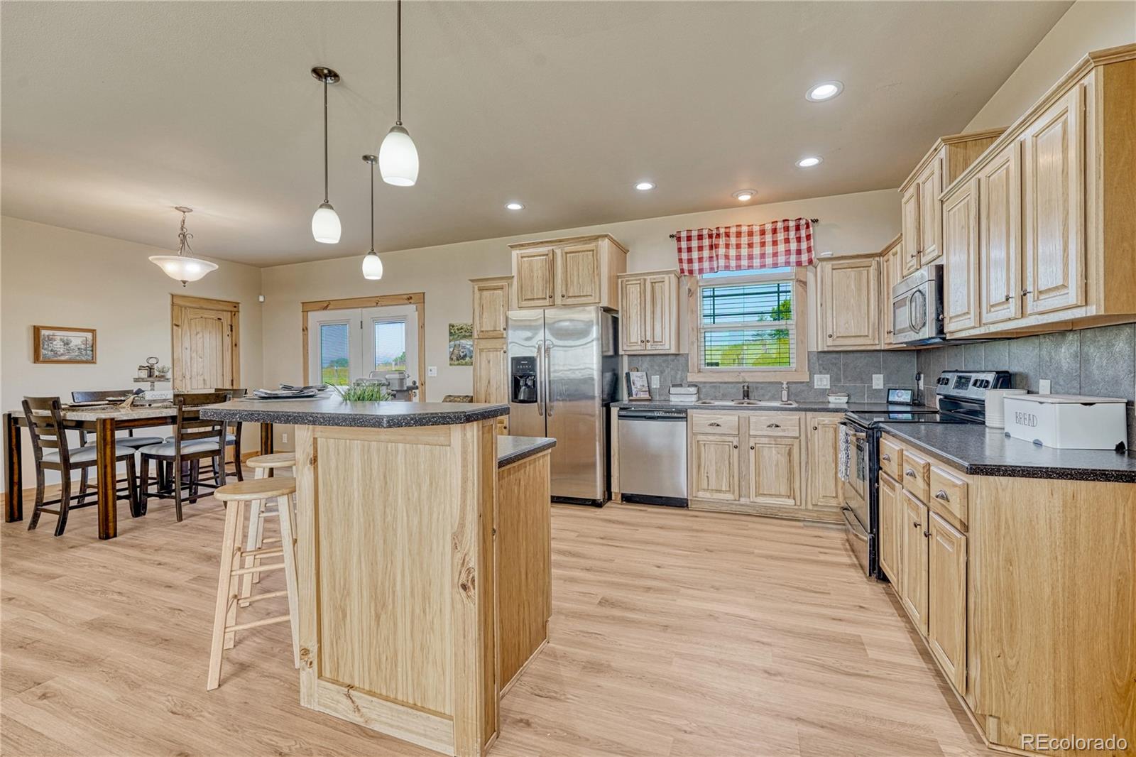17355 Wagon Train Loop Peyton, CO 80831 - Photo 9 of 48 a kitchen with stainless steel appliances granite countertop a refrigerator a stove top oven and a sink with cabinets