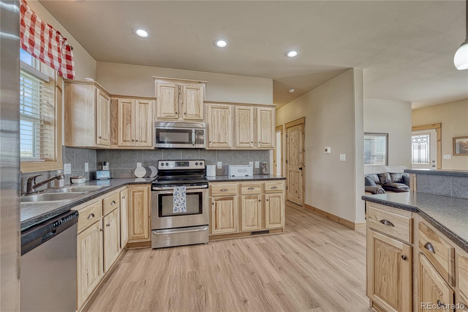 17355 Wagon Train Loop Peyton, CO 80831 - Photo 10 of 48 a kitchen with stainless steel appliances granite countertop a sink stove and refrigerator
