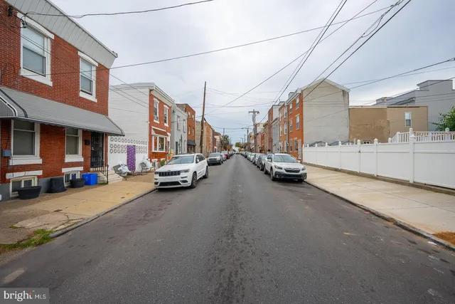 a view of a city street with parked cars