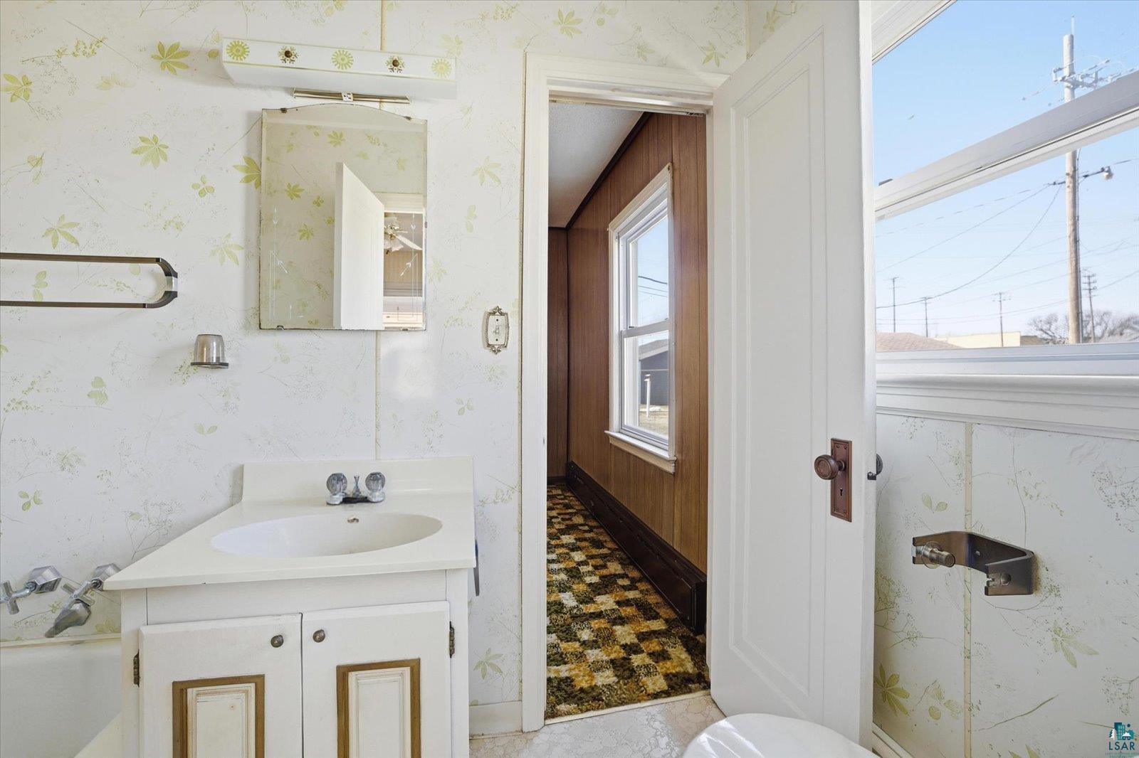 709 Michigan Street Hibbing, MN 55746 - Photo 11 of 47 Bathroom with wallpapered walls and vanity
