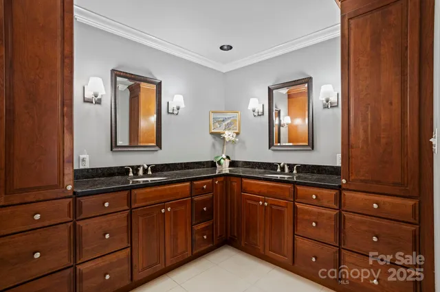a bathroom with a granite countertop double vanity sink and mirror
