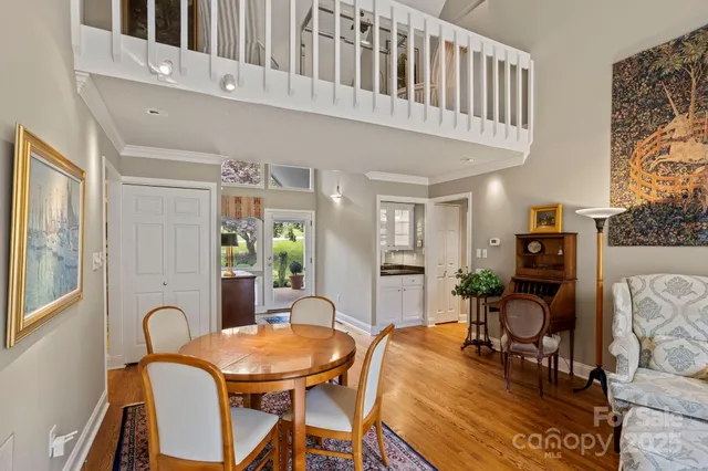 a living room with furniture a dining table and paintings on the wall