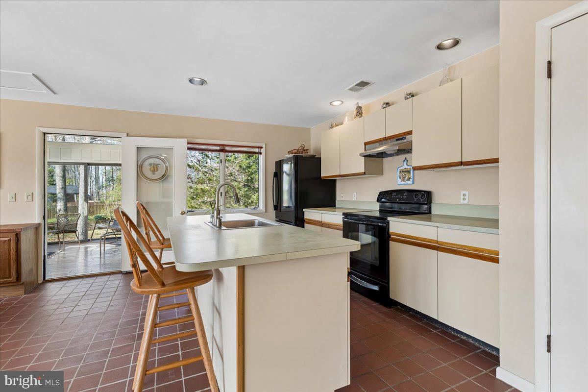 10087 John Carvill Road Chestertown, MD 21620 - Photo 13 of 63 a kitchen with stainless steel appliances granite countertop a refrigerator a stove a sink dishwasher a dining table and chairs with wooden floor