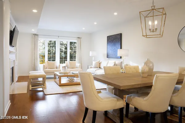 a dining room with furniture a chandelier and wooden floor