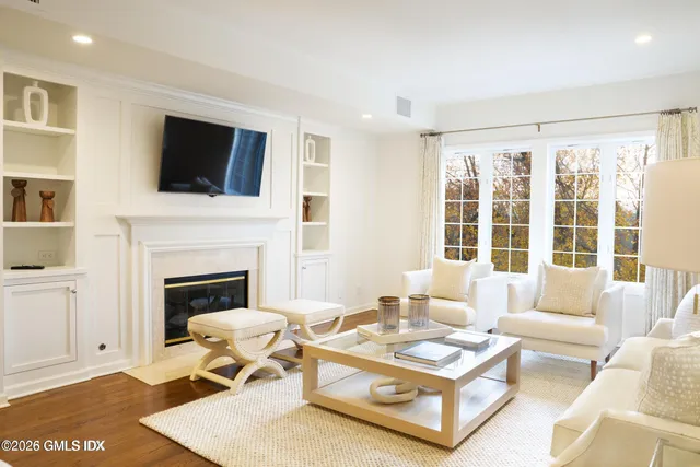 a living room with furniture a flat screen tv and a fireplace