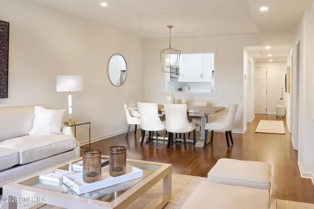 a dining room with wooden floor a glass table and chairs