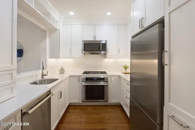 a kitchen with a sink stainless steel appliances and cabinets