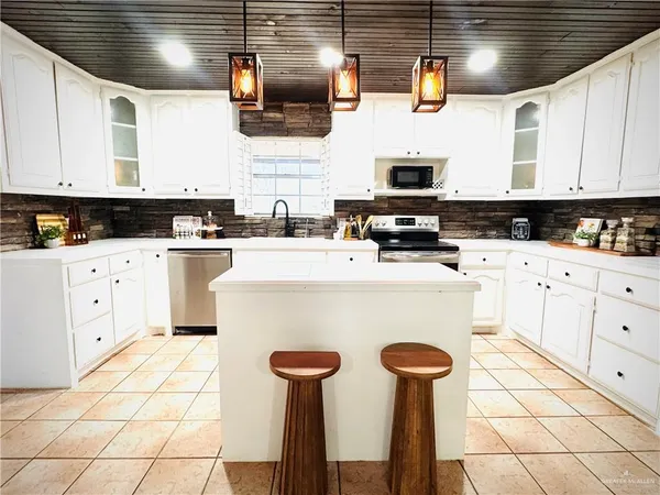 a kitchen with stainless steel appliances a refrigerator sink and cabinets