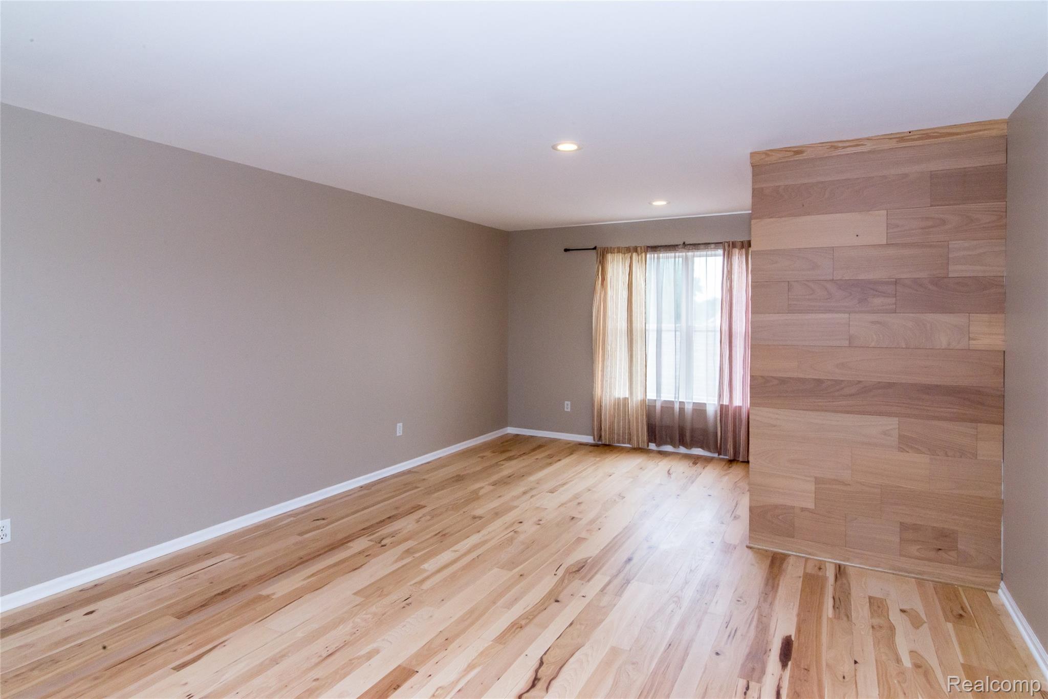 486 Sweet Briar Ridge Linden, MI 48451 - Photo 38 of 69 Hardwood flooring throughout, recessed lighting, and a wood-panel accent wall