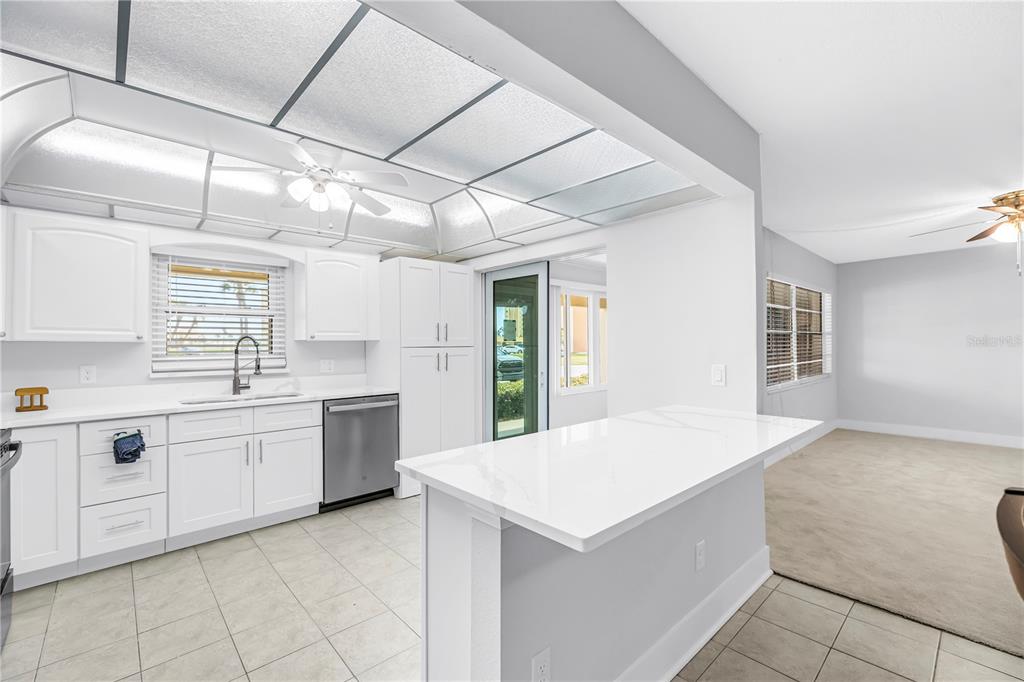 4700 Cove Circle, Unit 103 St. Petersburg, FL 33708 - Photo 11 of 31 a kitchen with granite countertop a sink and white cabinets
