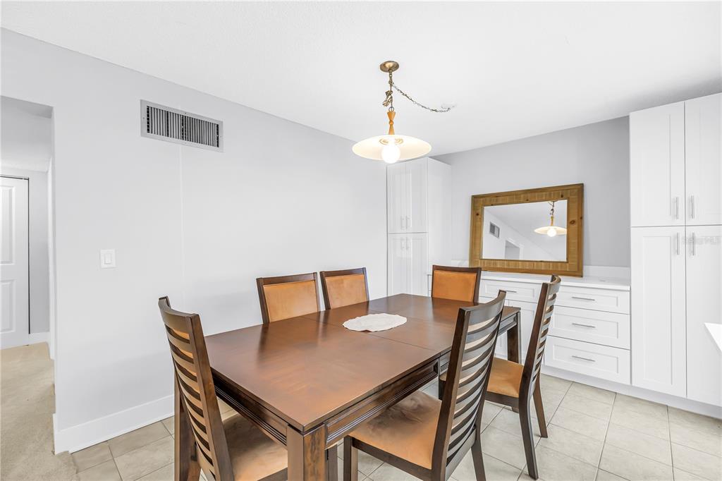 4700 Cove Circle, Unit 103 St. Petersburg, FL 33708 - Photo 12 of 31 a view of a dining room with furniture and wooden floor